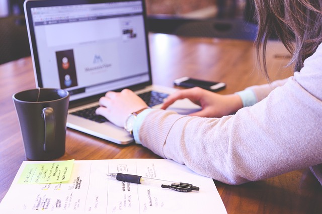 A person sitting at a desk researching exchange programs for students in Japan on laptop