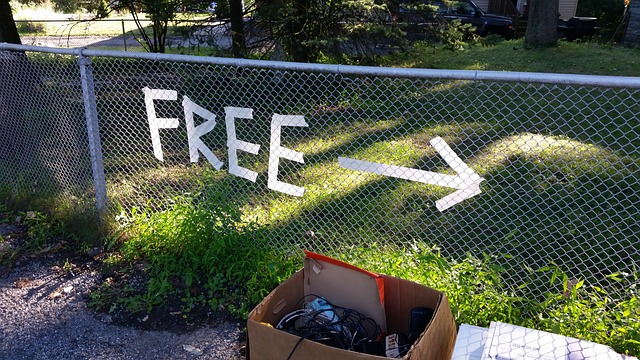 An errow on a fence and a sign saying free.