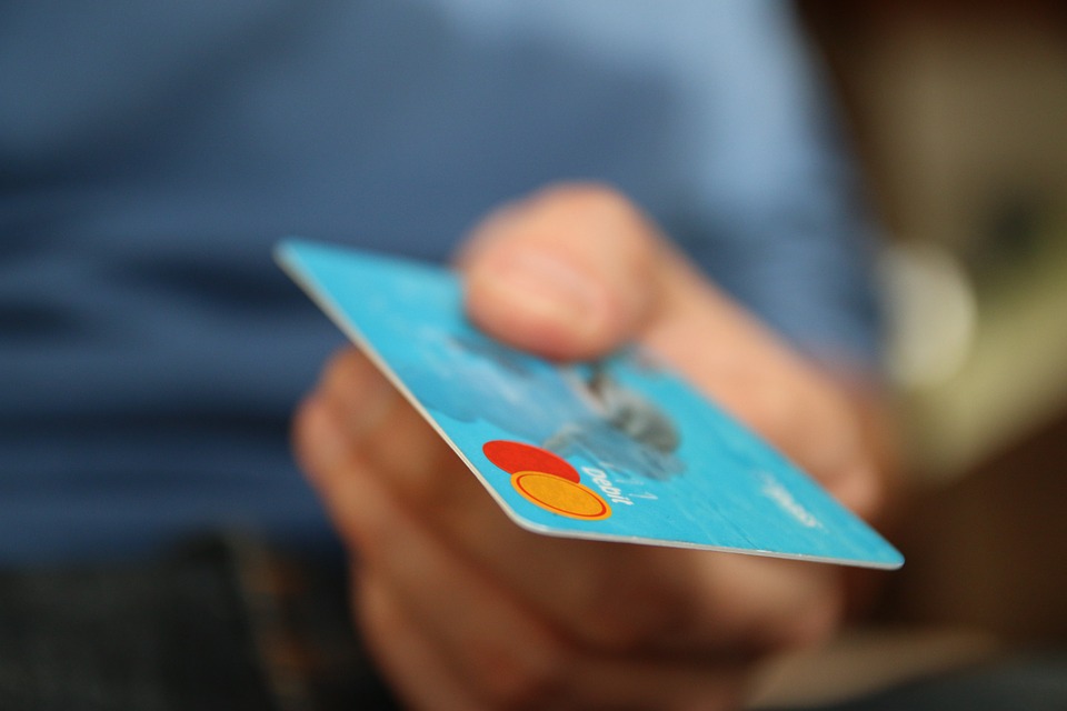 a light blue credit card being used while attempting to live cheap in Manhattan.